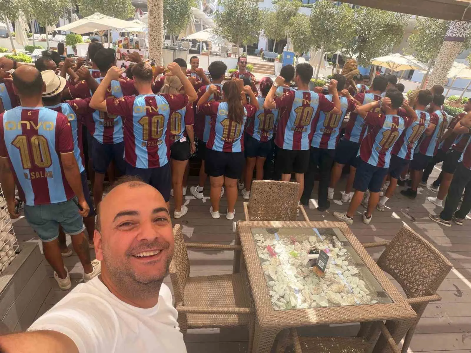 TRABZONSPOR’UN ESKİ BAŞKAN YARDIMCISI İŞ İNSANI MURAT BOZOĞLU, BORDO-MAVİ SEVGİSİNİ KIBRIS’IN GİRNE KENTİNDE DİKKAT ÇEKEN BİR ŞEKİLDE TAŞIDI. BOZOĞLU, DÜNYACA ÜNLÜ FUTBOLCU MOHAMED SALAH’IN TRABZONSPOR FORMALARINDAN 250 ADET SATIN ALARAK OTEL ÇALIŞANLARINA DAĞITTI.