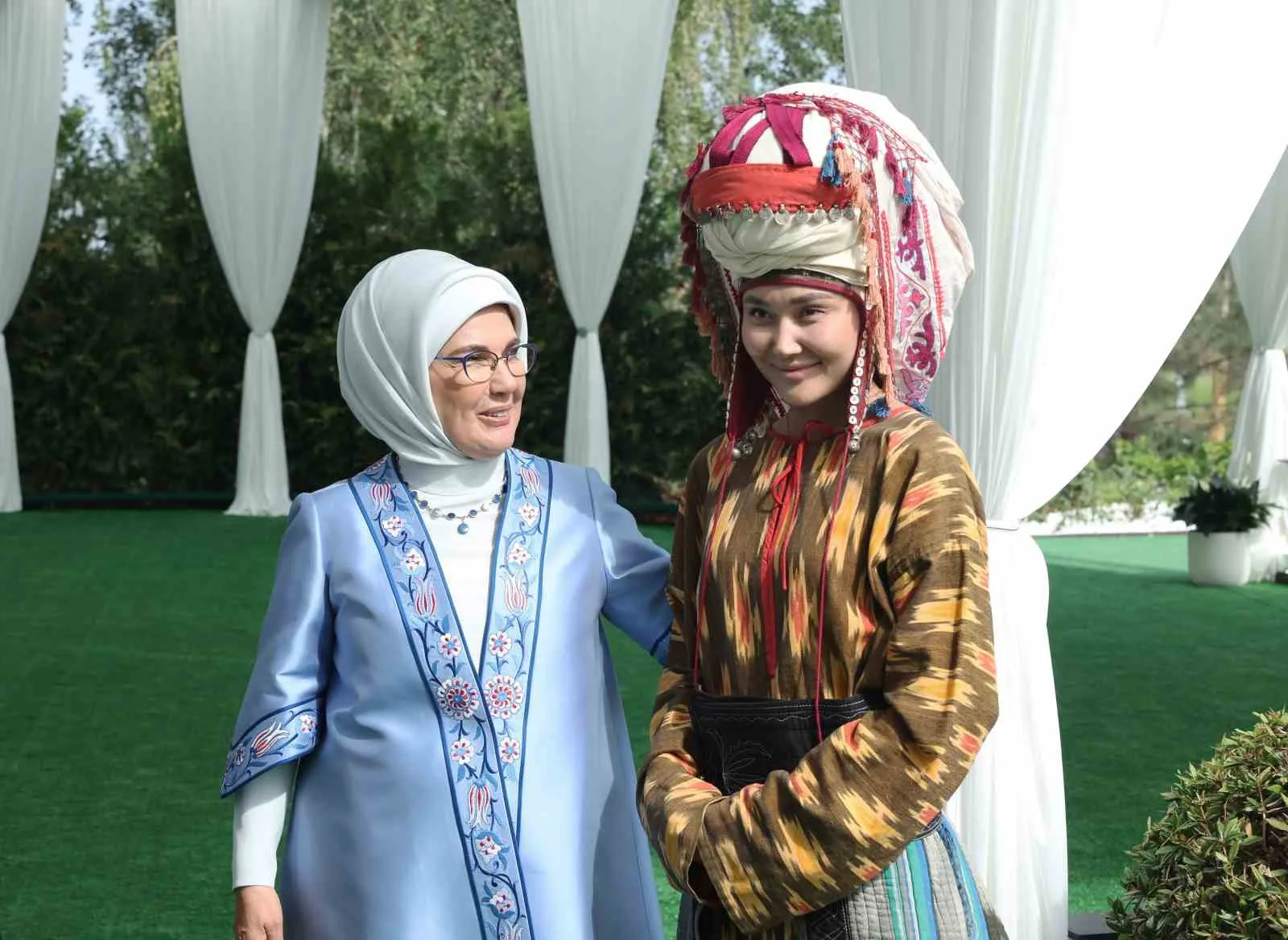 PROGRAM KAPSAMINDA KONUKEVİNİN PARKINDA YÜRÜYÜŞ YAPAN LİDER EŞLERİ, KIRGIZ ÇADIRINDA GELENEKSEL KIYAFETLER GİYEN ÇOCUKLARIN VE GENÇLERİN, ARALARINDA KOMUZUN DA OLDUĞU KIRGIZİSTAN'A ÖZGÜ ENSTRÜMANLARLA VERDİĞİ KONSERİ İLGİYLE TAKİP ETTİ.