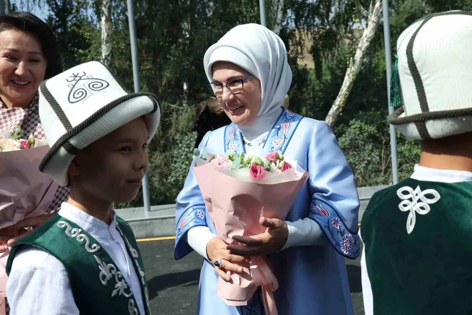 PROGRAM KAPSAMINDA KONUKEVİNİN PARKINDA YÜRÜYÜŞ YAPAN LİDER EŞLERİ, KIRGIZ ÇADIRINDA GELENEKSEL KIYAFETLER GİYEN ÇOCUKLARIN VE GENÇLERİN, ARALARINDA KOMUZUN DA OLDUĞU KIRGIZİSTAN'A ÖZGÜ ENSTRÜMANLARLA VERDİĞİ KONSERİ İLGİYLE TAKİP ETTİ.