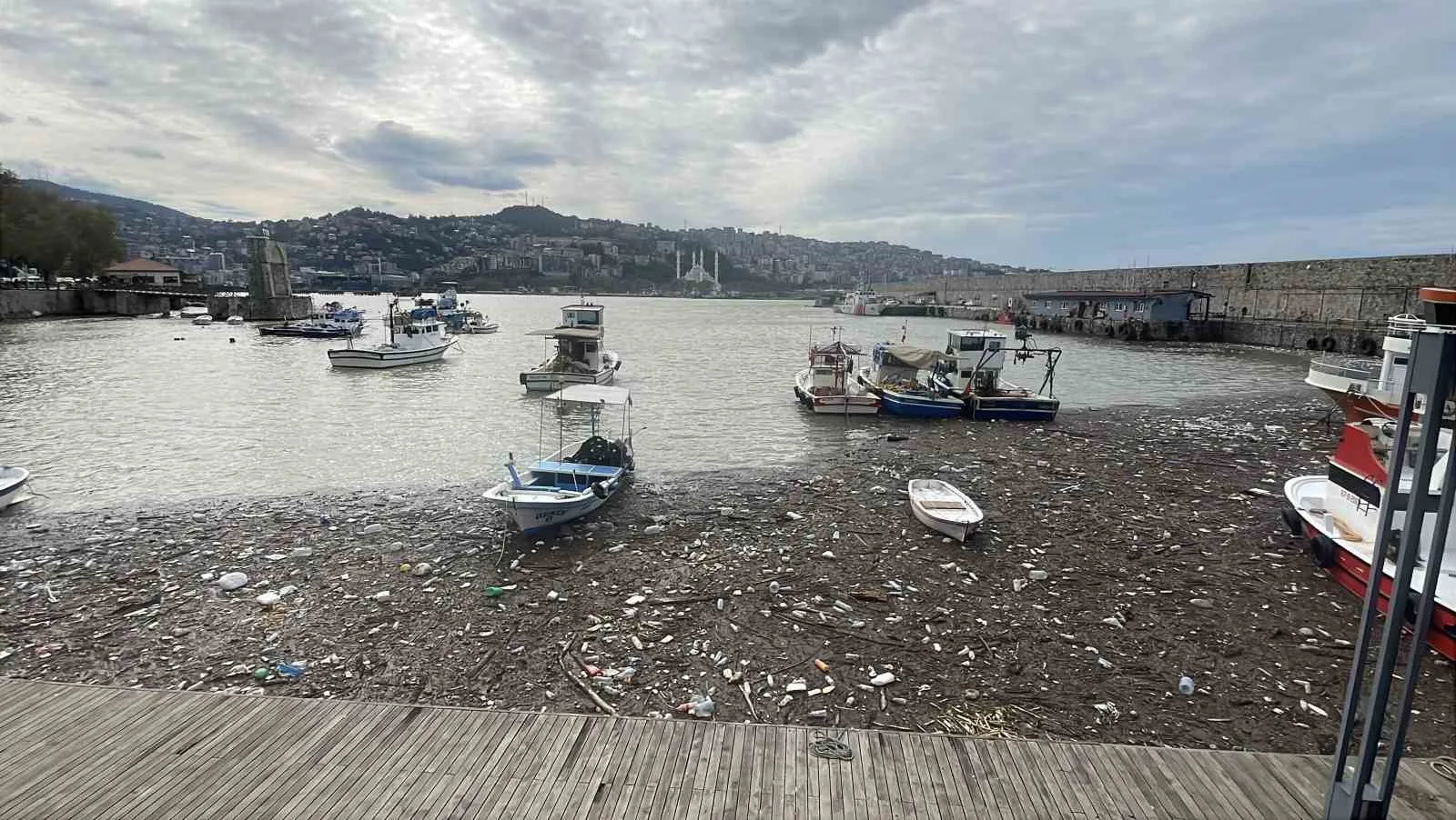 ZONGULDAK'TA GÜNLERDİR ETKİLİ OLAN ŞİDDETLİ YAĞIŞLARIN ARDINDAN ÇAYDAMAR VE ÜZÜLMEZ DERELERİNİN SÜRÜKLEDİĞİ TONLARCA ATIK, LİMANDA BİRİKTİ. PLASTİK ŞİŞELER, AĞAÇ PARÇALARI, MOLOZ VE EVSEL ATIKLARIN KAPLADIĞI DENİZ YÜZEYİNDE BALIKÇI TEKNELERİ ÇÖPLERİN ARASINDA KALDI.