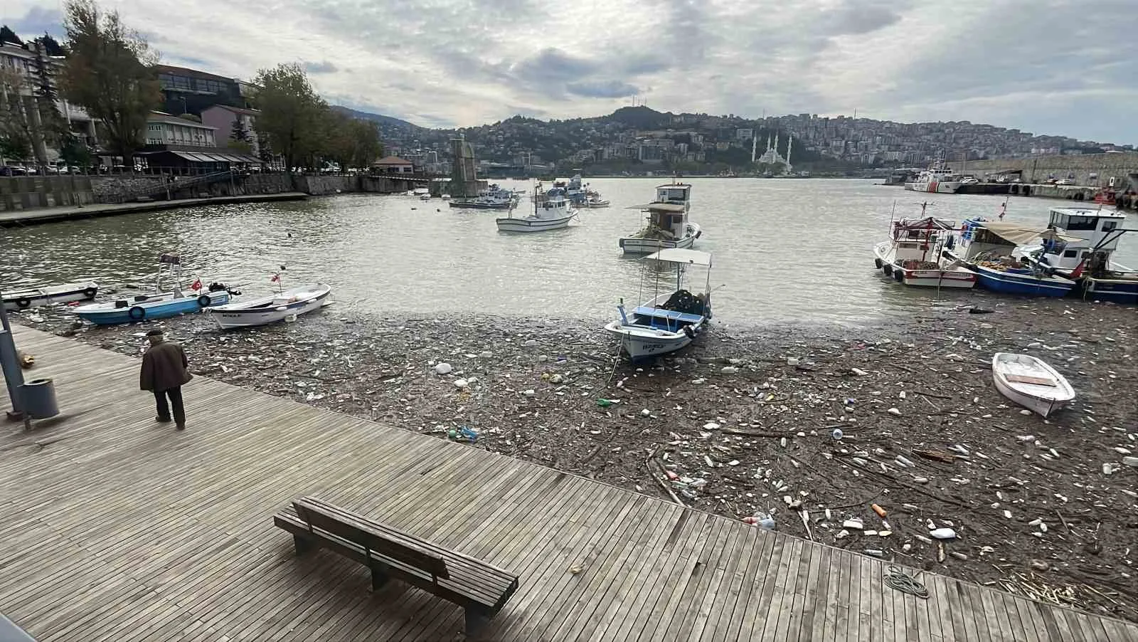 ZONGULDAK'TA GÜNLERDİR ETKİLİ OLAN ŞİDDETLİ YAĞIŞLARIN ARDINDAN ÇAYDAMAR VE ÜZÜLMEZ DERELERİNİN SÜRÜKLEDİĞİ TONLARCA ATIK, LİMANDA BİRİKTİ. PLASTİK ŞİŞELER, AĞAÇ PARÇALARI, MOLOZ VE EVSEL ATIKLARIN KAPLADIĞI DENİZ YÜZEYİNDE BALIKÇI TEKNELERİ ÇÖPLERİN ARASINDA KALDI.